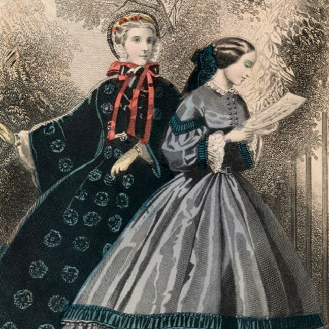 Two women in Victorian-era dresses standing outdoors with trees in the background